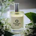 A clear glass perfume bottle with a reflective silver cap and a cream-colored label reading 'Péntaura N°149', styled with white flowers and green leaves around it
