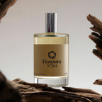 A bottle of Péntura N°361 perfume with a beige label and silver cap, displayed on a piece of driftwood against a neutral background.
