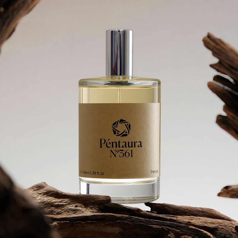 A bottle of Péntura N°361 perfume with a beige label and silver cap, displayed on a piece of driftwood against a neutral background.