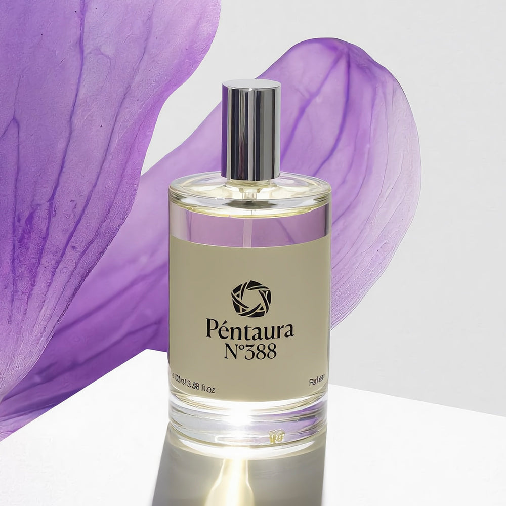 Péntaura N° 388 fragrance bottle with a silver cap and beige label, set against large purple flower petals on a white reflective surface.