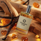 A bottle of Pentaurea N°90 perfume with a cream label and silver cap, surrounded by amber resin pieces, vanilla beans, and warm wood in a styled product shot.
