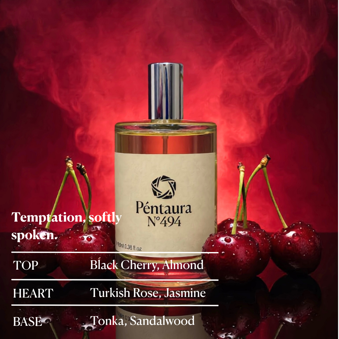 A bottle of Péntura N°494 fragrance centered against a dramatic red smoky background, surrounded by glossy red cherries. White text on the left lists scent notes: TOP Black Cherry, Almond; HEART Turkish Rose, Jasmine; BASE Tonka, Sandalwood.